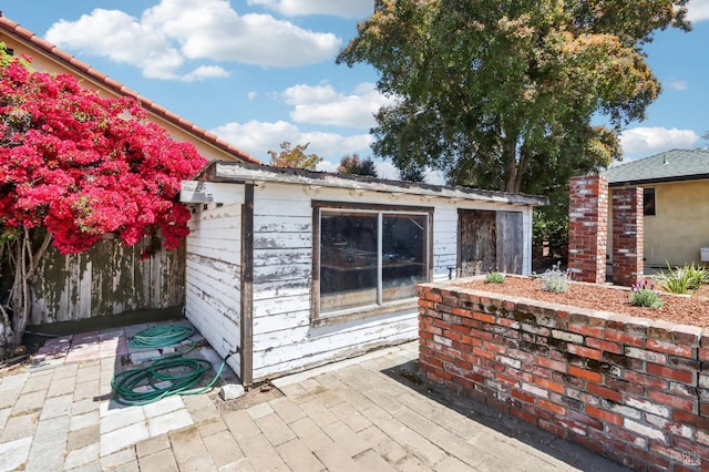 view of outdoor structure featuring fence and an outbuilding