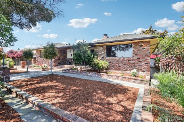 single story home with fence, a chimney, and brick siding
