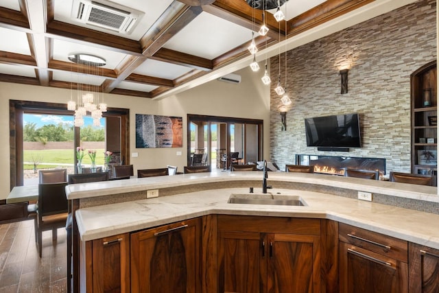 kitchen with visible vents, beam ceiling, a sink, a notable chandelier, and open floor plan