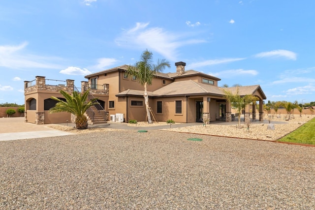 view of front of property featuring stairs, stucco siding, and a patio