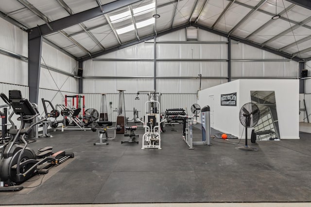 exercise room with a garage and high vaulted ceiling