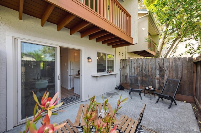 view of patio / terrace with fence and a balcony