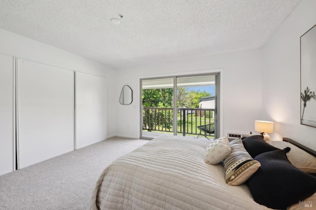 bedroom with carpet floors, access to outside, a textured ceiling, and a closet