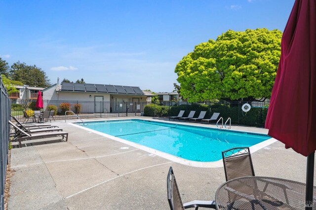 pool with a patio and fence