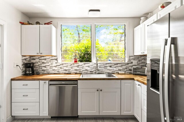 1722 Elm St, Napa, CA 94559 - kitchen with wooden counters, appliances with stainless steel finishes, a sink, tasteful backsplash, and white cabinetry