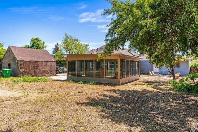 rear view of property with a sunroom and a patio area
