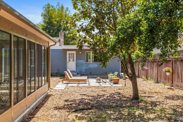 view of yard featuring fence and a sunroom