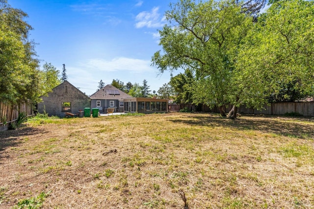 view of yard with a sunroom and a fenced backyard