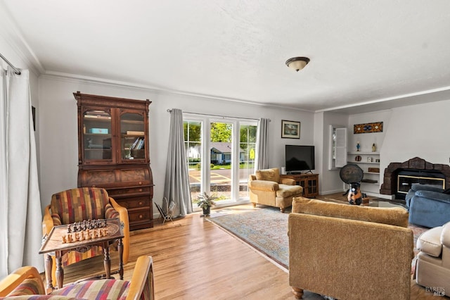 living area with crown molding and light wood-style flooring