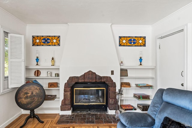 sitting room with baseboards, ornamental molding, a glass covered fireplace, and built in shelves