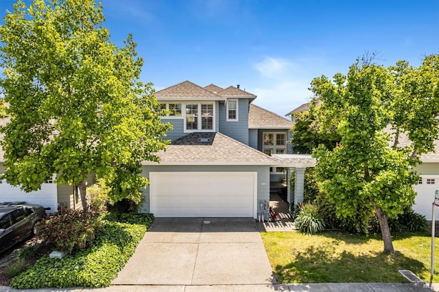 view of front of house featuring concrete driveway and a shingled roof