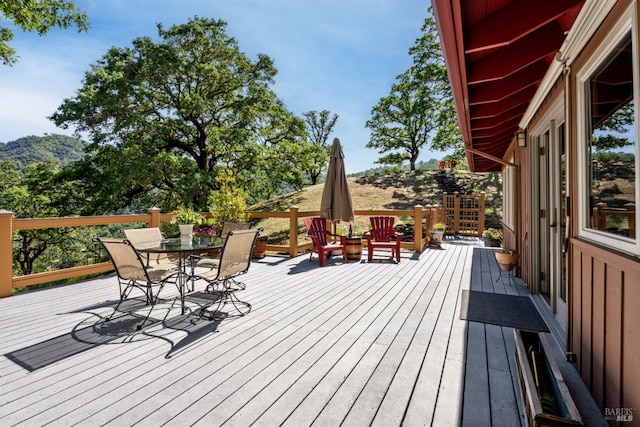 wooden terrace with a mountain view and outdoor dining area