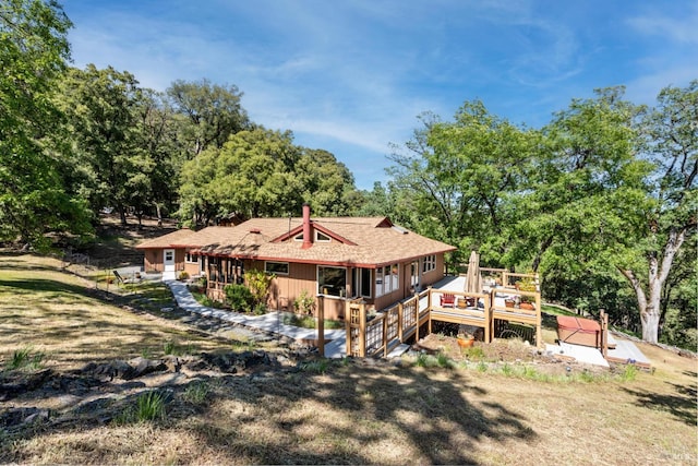back of property featuring roof with shingles and a wooden deck