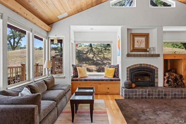 living area with wood ceiling, a fireplace, vaulted ceiling, and wood finished floors