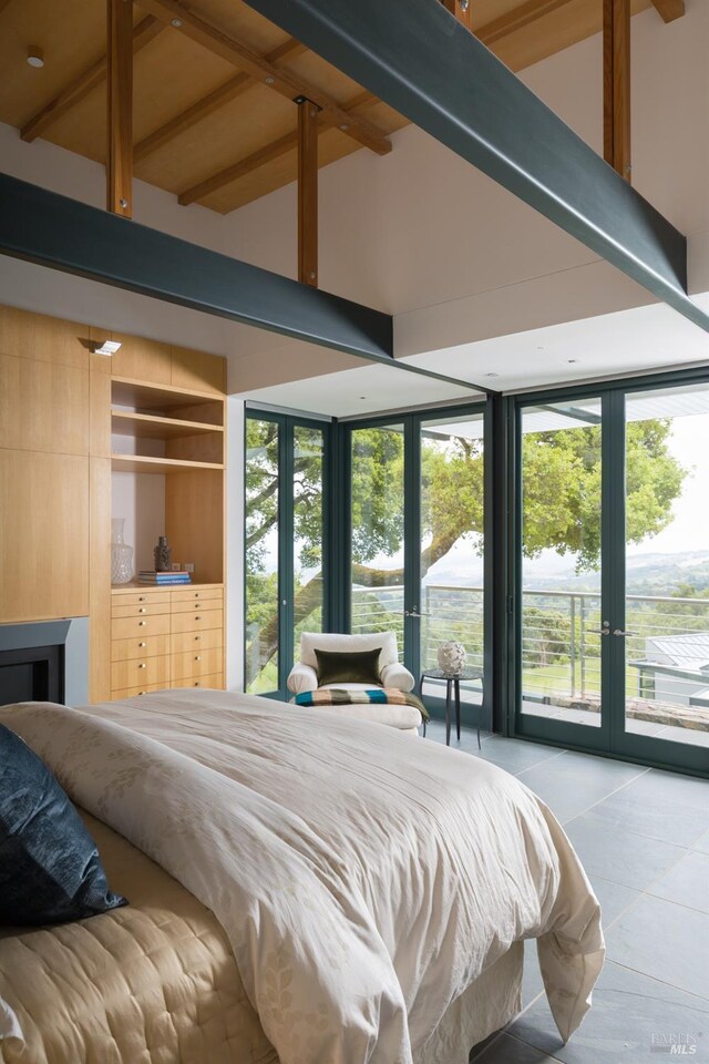 bedroom with tile patterned floors, access to outside, french doors, and multiple windows