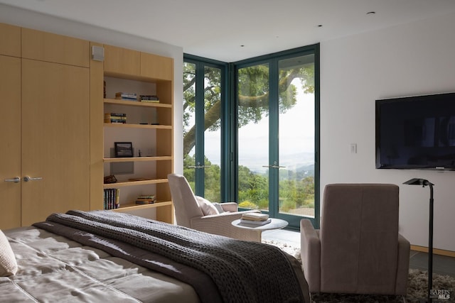 bedroom with french doors, floor to ceiling windows, and multiple windows
