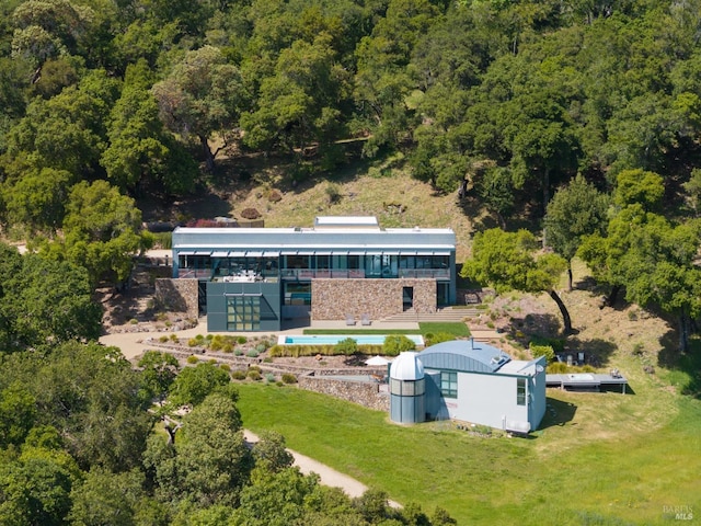 drone / aerial view featuring a wooded view