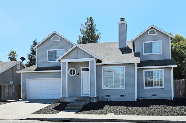 traditional-style house featuring a garage, fence, a shingled roof, and concrete driveway