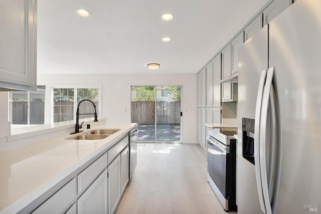 kitchen with recessed lighting, a sink, light wood-style floors, and appliances with stainless steel finishes