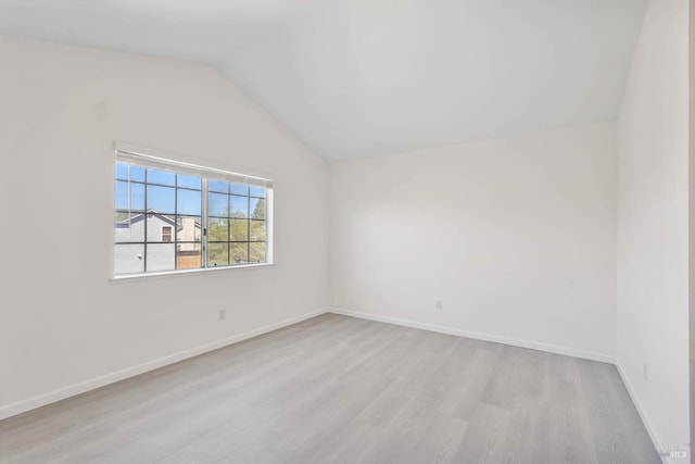 empty room with baseboards, wood finished floors, and lofted ceiling