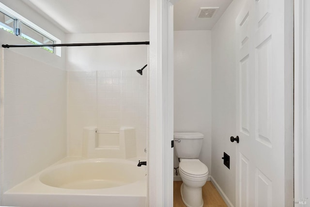 bathroom with visible vents, shower / bathtub combination, wood finished floors, toilet, and baseboards
