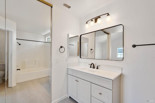 full bath featuring visible vents, wood finished floors, vanity, baseboards, and toilet