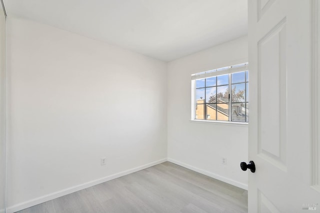 unfurnished room with baseboards and wood finished floors