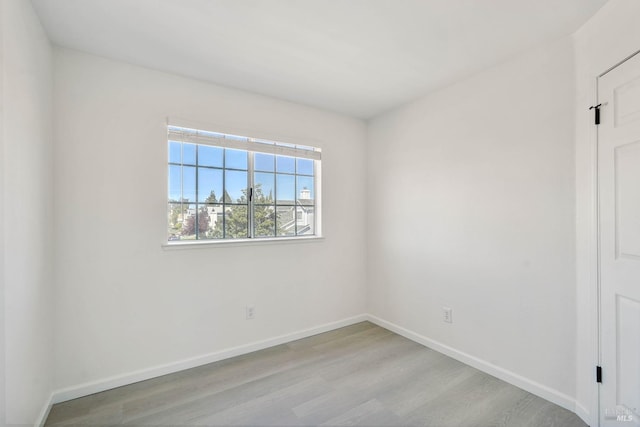 empty room with baseboards and wood finished floors