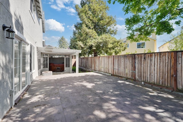 view of patio / terrace featuring a fenced backyard, a hot tub, and a pergola