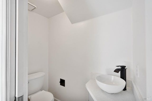 bathroom with a sink, baseboards, and toilet
