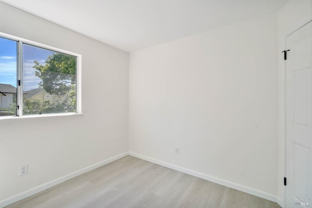 unfurnished room with baseboards and light wood-type flooring