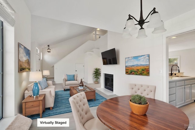 dining space with a fireplace with raised hearth and high vaulted ceiling