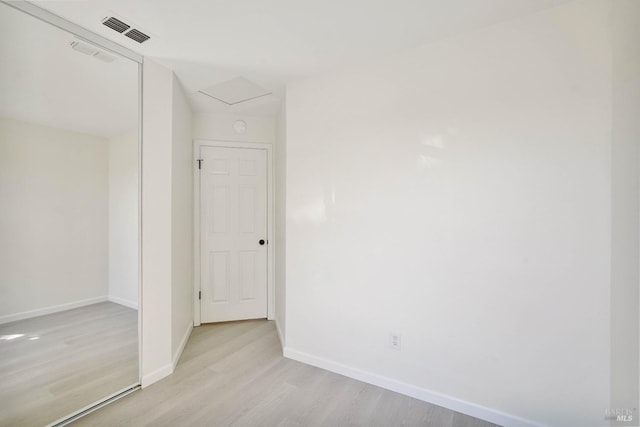 interior space featuring baseboards, light wood-type flooring, and visible vents