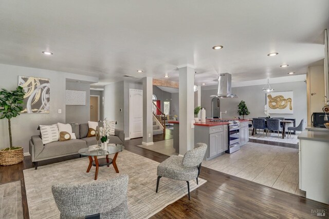 living room with stairs, recessed lighting, and light wood-type flooring