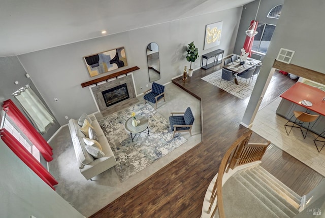 living room featuring visible vents, wood finished floors, baseboards, a glass covered fireplace, and recessed lighting