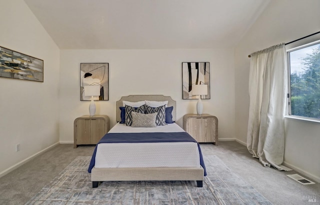 carpeted bedroom featuring baseboards, vaulted ceiling, and visible vents