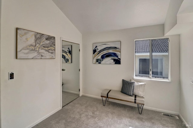 sitting room with visible vents, carpet flooring, baseboards, and vaulted ceiling