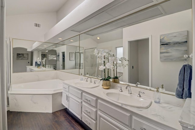 full bath featuring a sink, a shower stall, wood finished floors, and visible vents