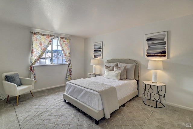 bedroom featuring baseboards and light colored carpet