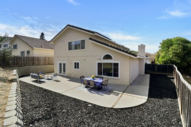 back of property with a patio, a fenced backyard, an outdoor fire pit, and stucco siding