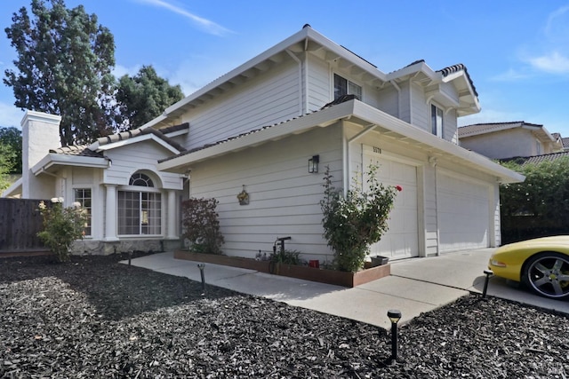 view of property exterior featuring fence, driveway, a chimney, and a garage