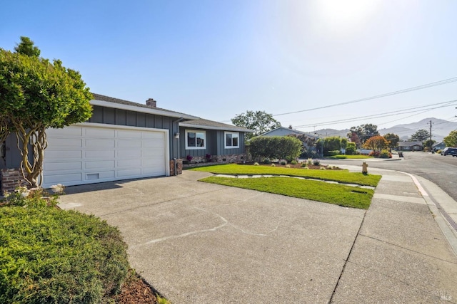16 Tradewind Psge, Corte Madera, CA 94925 - ranch-style house featuring board and batten siding, a chimney, a front lawn, concrete driveway, and an attached garage