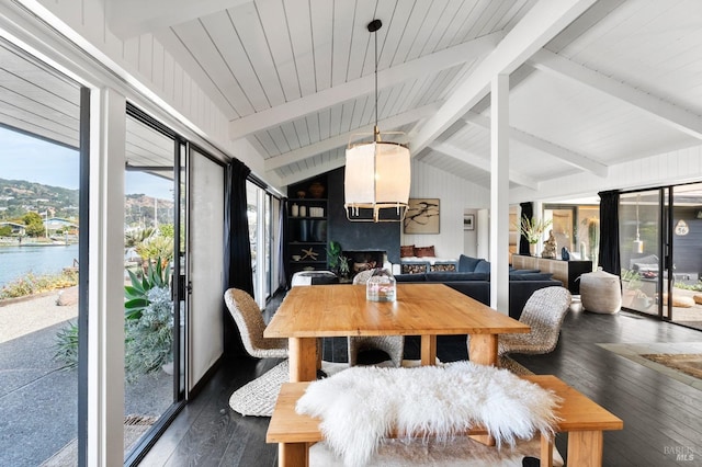 sunroom featuring a water view and beamed ceiling