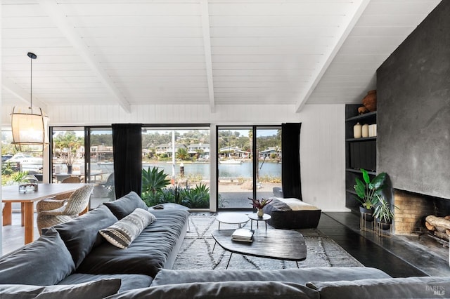 living room featuring a water view, lofted ceiling with beams, and wood finished floors