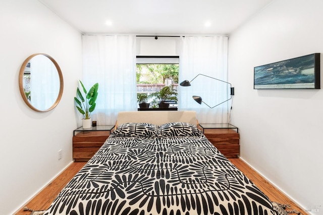 bedroom with recessed lighting and wood finished floors