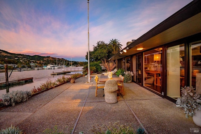 view of patio with outdoor dining area and a water view