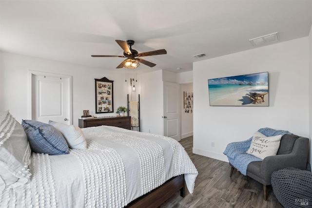bedroom featuring visible vents, baseboards, ceiling fan, and wood finished floors