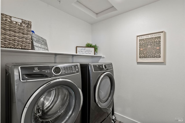 clothes washing area with baseboards, laundry area, attic access, and washer and dryer