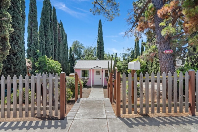 view of front of property with a gate, an outbuilding, and a fenced front yard