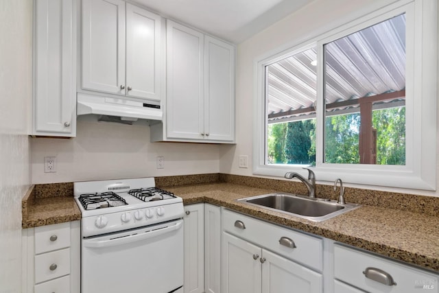 kitchen with a sink, under cabinet range hood, white range with gas stovetop, and white cabinetry